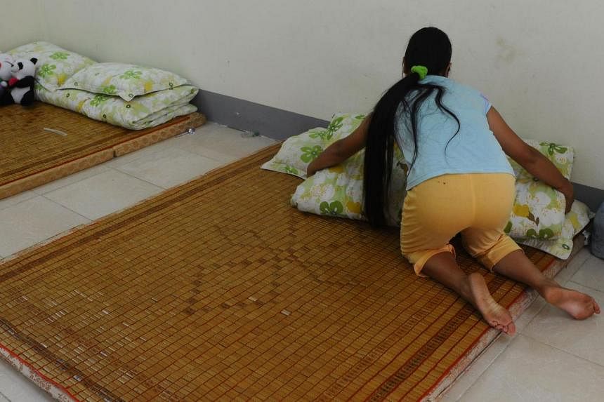Ethnic H'mong girl Kiab (whose name has been changed to protect her identity) arranging her bed at a government-run centre for trafficked women in the northern city of Lao Cai. When Kiab turned 16, her brother promised to take her to a party in a tou