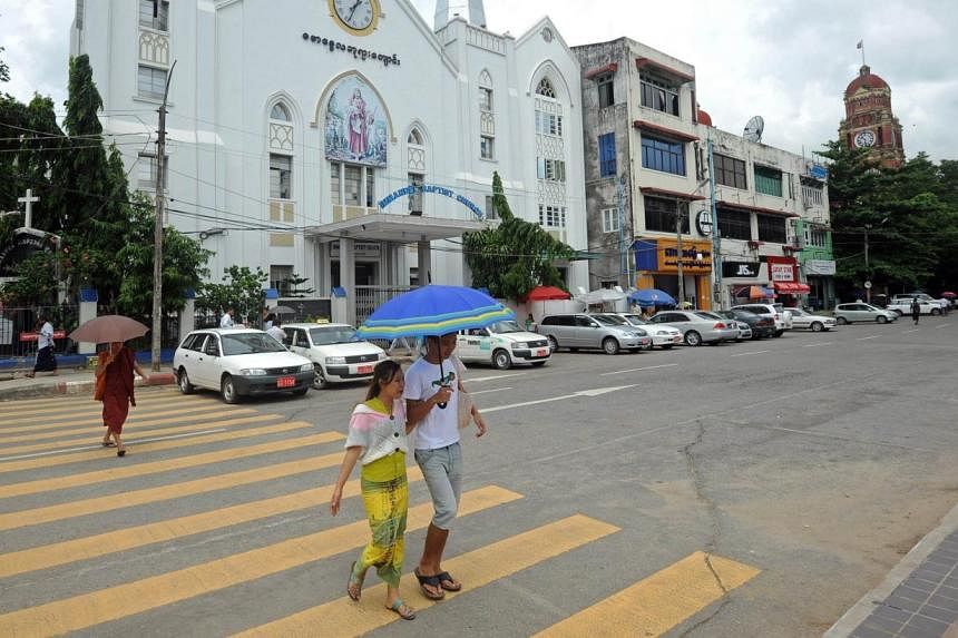 A couple crossing a road before a church in Yangon. Proposals by radical Buddhist monks to criminalise inter-faith marriage in Myanmar face strong opposition from women's rights groups in a tussle over the nation's religious identity that has sparked