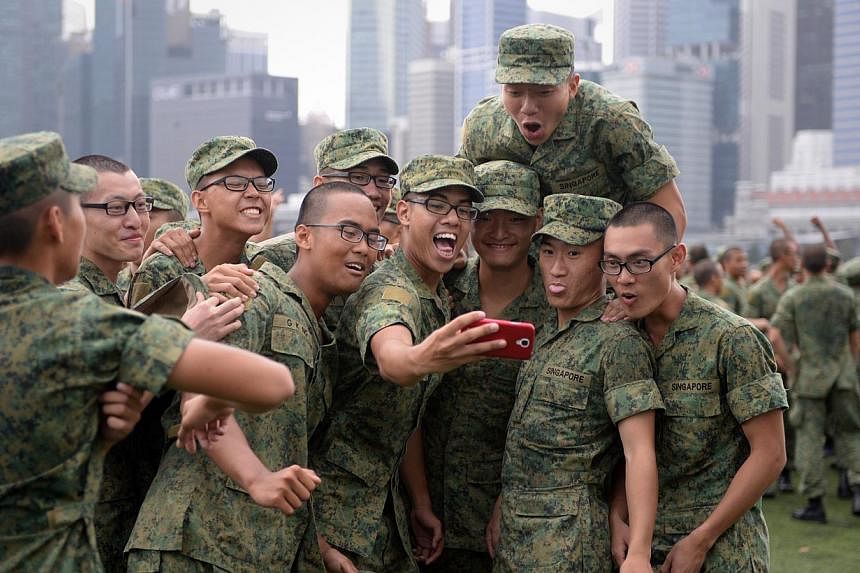 Recruits celebrating after their Basic Military Training passing out parade held at the Floating Platform@Marina Bay in April. -- ST PHOTO: MARK CHEONG