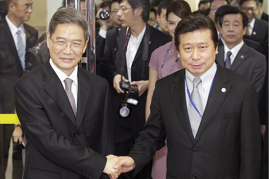 Mr Zhang Zhijun (left), director of China's Taiwan Affairs Office, shakes hands with Mainland Affairs Council Vice Minister Chang Hsien-yao, after arriving at Taoyuan International Airport, northern Taiwan on June 25, 2014. -- PHOTO: REUTERS