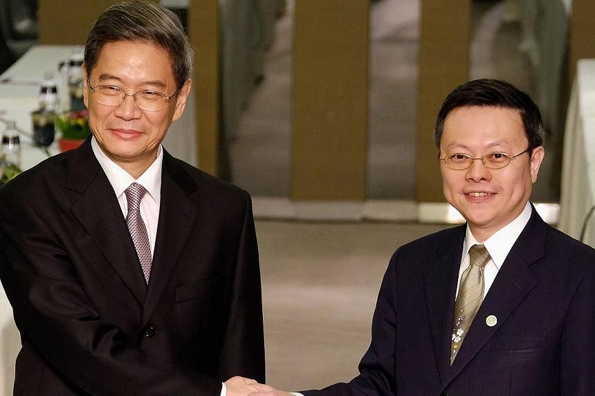Chinese official Zhang Zhijun (L), director of the Taiwan Affairs Office, shakes hands with his Taiwanese counterpart Wang Yu-chi, director of Taiwan's Mainland Affairs Council (MAC), at a hotel in Taoyuan on June 25, 2014. -- PHOTO: AFP