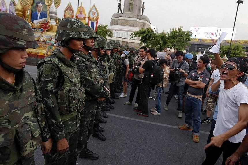 Protesters against military rule face soldiers at the Victory monument in Bangkok on May 26, 2014. -- PHOTO: REUTERS
