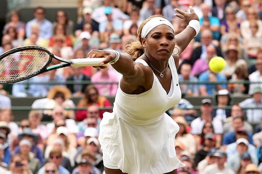 US player Serena Williams returns to Russia's Chanelle Scheepers during their women's singles second round match on day four of the 2014 Wimbledon Championships at The All England Tennis Club in Wimbledon, south-west London, on June 26, 2014. -- PHOT