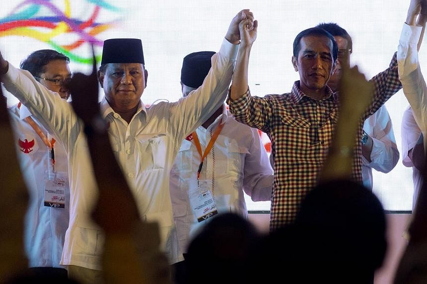 Indonesian presidential candidates Prabowo Subianto (left) and Joko Widodo joining hands on stage after signing a declaration calling for peaceful elections during a ceremony on June 3 in Jakarta.