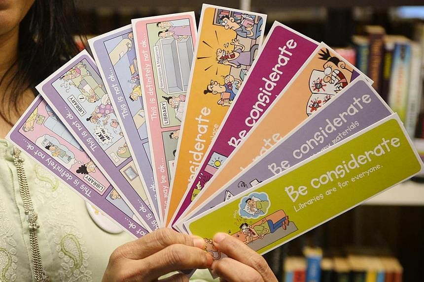 These bookmarks are among the materials designed by ST artist Lee Chee Chew that use humour to influence social behaviour. Volunteer Saberah Begum (right), a pre-school teacher, passing a bookmark and explaining good library habits to Zuhairah Ubaidi