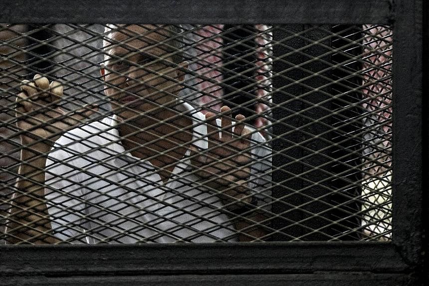 Al-Jazeera news channel's Australian journalist Peter Greste listens to the verdict inside the defendants cage during his trial for allegedly supporting the Muslim Brotherhood on June 23, 2014. -- PHOTO: AFP&nbsp;