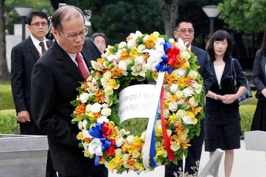 Philippine President Benigno Aquino (front left) lays a weath on an altar for the A-bomb victims at the Peace Memorial Park in Hiroshima on June 24, 2014. -- PHOTO: AFP