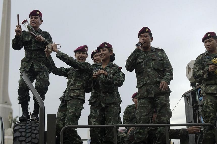 Thai soldiers sing as they stand on an army truck to entertain people at Victory monument in Bangkok&nbsp;on June 5, 2014. -- PHOTO: AFP