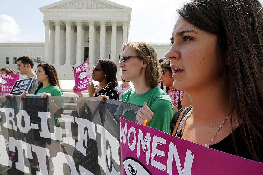 Anti-abortion protestors sing as they await the U.S. Supreme Court's ruling on a Massachusetts law that mandated a protective buffer zone around abortion clinics, outside the Court in Washington on June 26, 2014. -- PHOTO: REUTERS