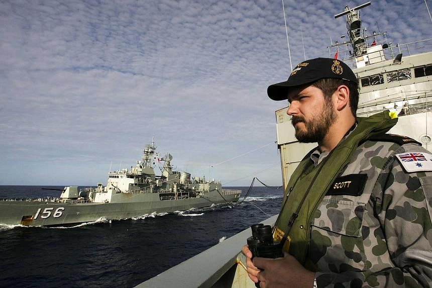 A file handout photo taken on April 7, 2014 and released on April 11 by the Australian Defence shows Able Seaman Maritime Logistics – Steward Kirk Scott keeping watch on the forecastle of auxiliary oiler HMAS Success as they conduct a Replenishment