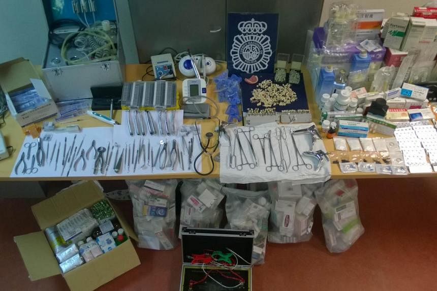 An undated handout picture released on June 27, 2014 by the Spanish National Police shows teeth, pills and numerous unsterilised forceps and dental tools seized at illegal Chinese clinics in Madrid. Spanish police busted a Chinese gang accused of car