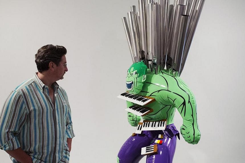 A man inspects the sculpture Hulk (Organ) during a press preview before the opening of a Jeff Koons retrospective at the Whitney Museum of American Art in New York on June 24, 2014. -- PHOTO: REUTERS