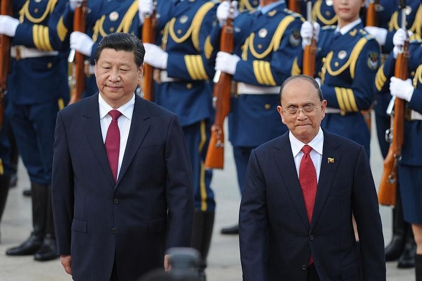 Myanmar President U Thein Sein (right) and Chinese President Xi Jinping (left) inspect Chinese honour guards during a welcome ceremony outside the Great Hall of the People in Beijing on June 27, 2014.&nbsp;Chinese President Xi Jinping feted neighbour