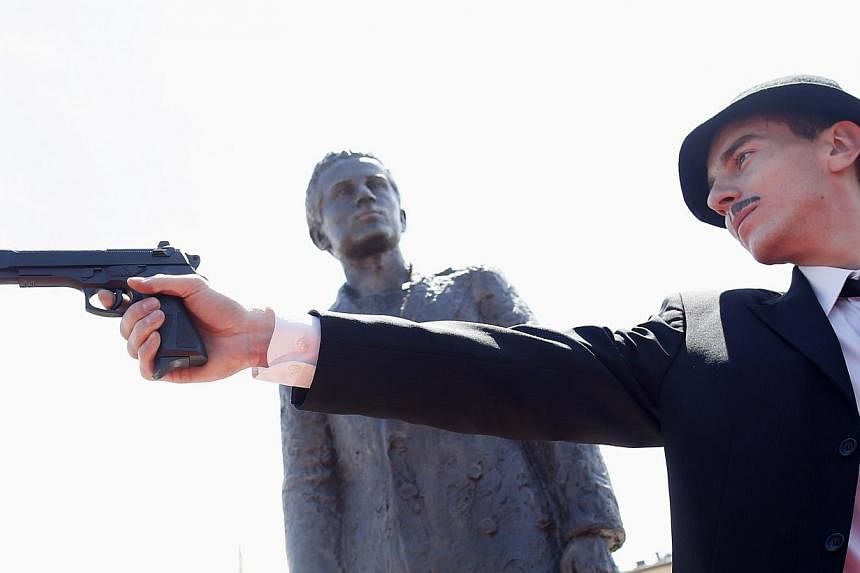 Jovan Mojsilovic, an actor, re-enacts Gavrilo Princip's assassination in front of a statue of Prinsip after it was uncovered during an opening ceremony in East Sarajevo on June 27, 2014.&nbsp;Sarajevo on Saturday, June 28, 2014, marked 100 years sinc