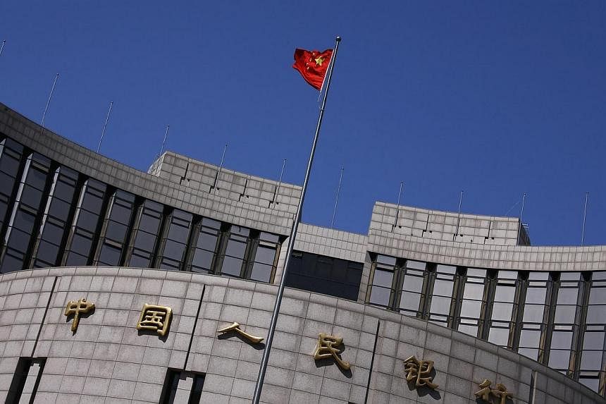 A Chinese national flag flutters outside the headquarters of the People's Bank of China, the Chinese central bank, in Beijing, April 3, 2014. -- PHOTO: REUTERS&nbsp;