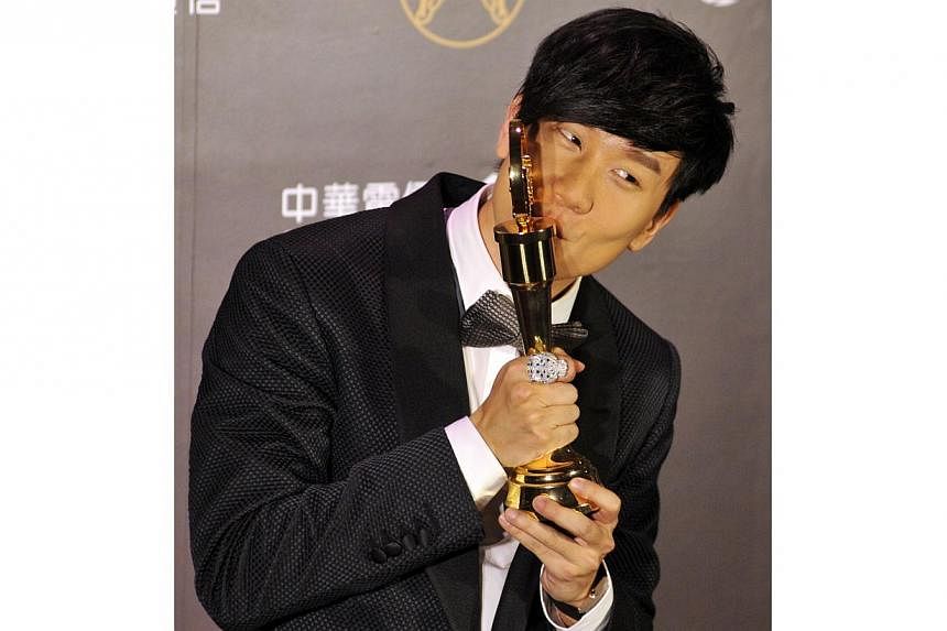 Singaporean singer-songwriter JJ Lin kisses his trophy after winning the Best Mandarin Male Singer at the 25th Golden Melody Awards in Taipei on June 28, 2014. -- PHOTO: AFP