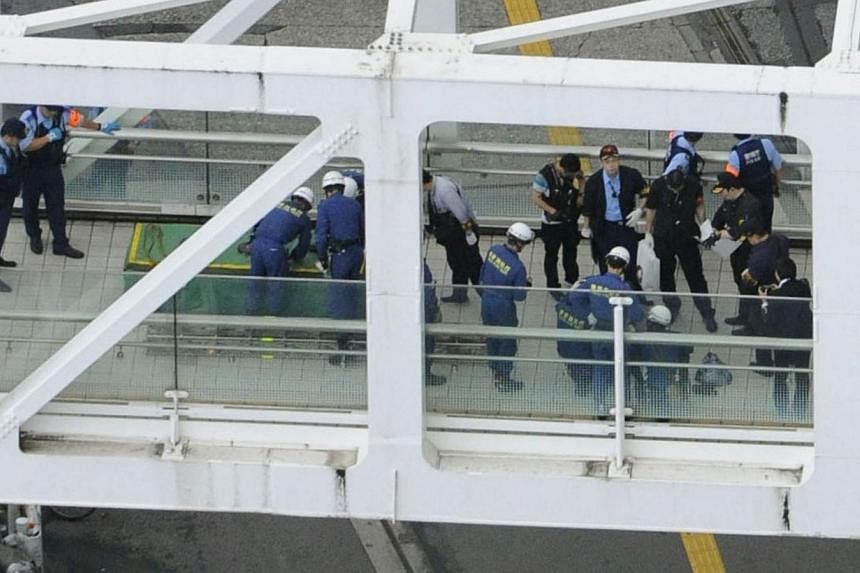 Police officers and firefighters investigating the site where a man set himself on fire at a pedestrian walkway near Shinjuku station in Tokyo, in this photo taken by Kyodo on June 29, 2014. The man set himself on fire at a busy intersection in Tokyo