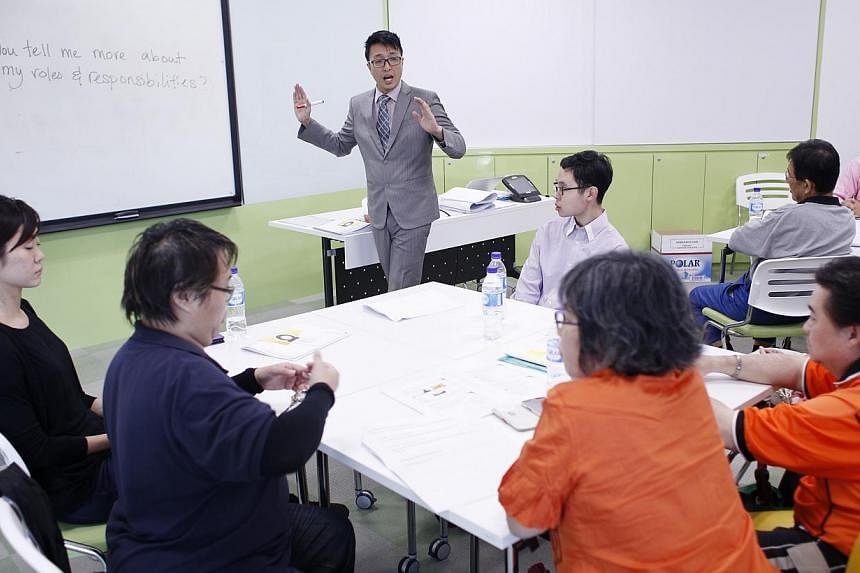 A trainer with SG Enable, Rupert Gan, 35 (centre) speaks to participants of a training workshop at the Lifelong Learning Institute on 25 June, 2014. Such training workshops for disabled job seekers are organised by SG Enable and they cover topics suc