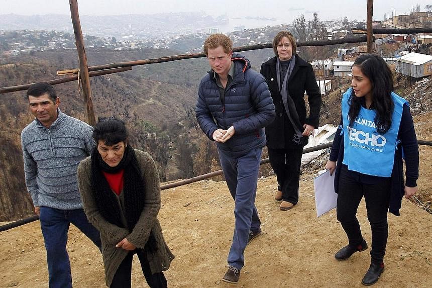 Britain's Prince Harry (centre) walks with members of the non-governmental organization TECHO as he tours El Vergel neighbourhood in Valparaiso city on June 28, 2014. -- PHOTO: REUTERS