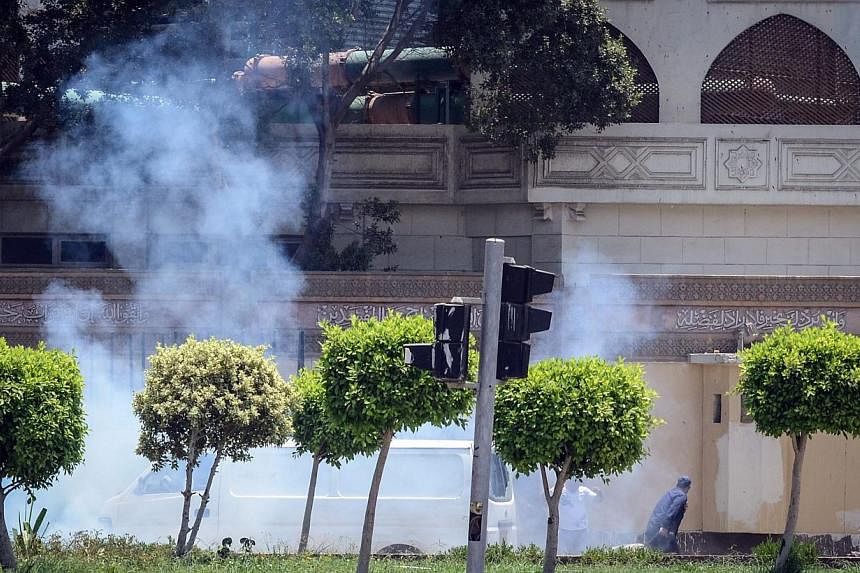 People run for cover moments after a bomb blast in the vicinity of the Ittihadiya palace in the Egyptian capital Cairo, on June 30, 2014.&nbsp;Two Egyptian police officers were killed defusing bombs near the presidential palace in Cairo on Monday, al