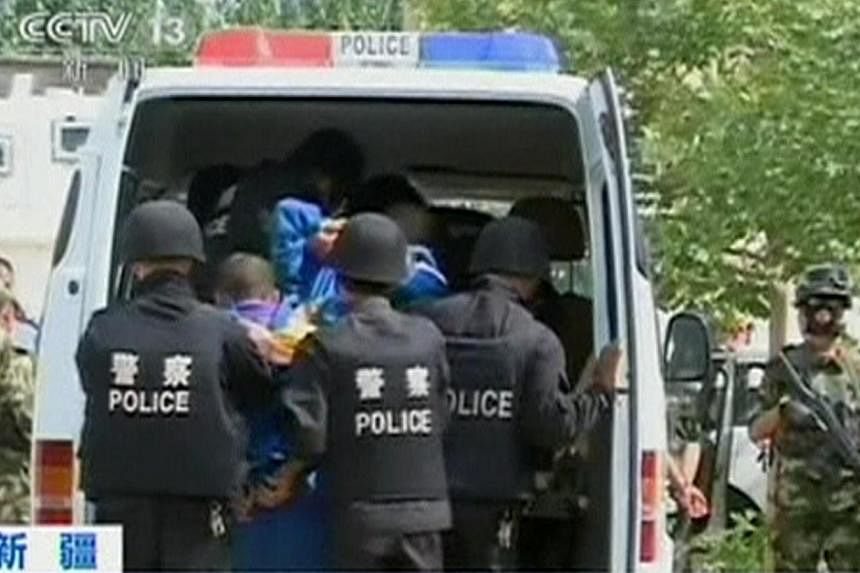 Riot policemen lead men who are about to be executed into a police van in this still image taken from video in an unknown location in the Xinjiang Uighur Autonomous Region, June 16, 2014. Courts in China's western Xinjiang region have sentenced 113 p