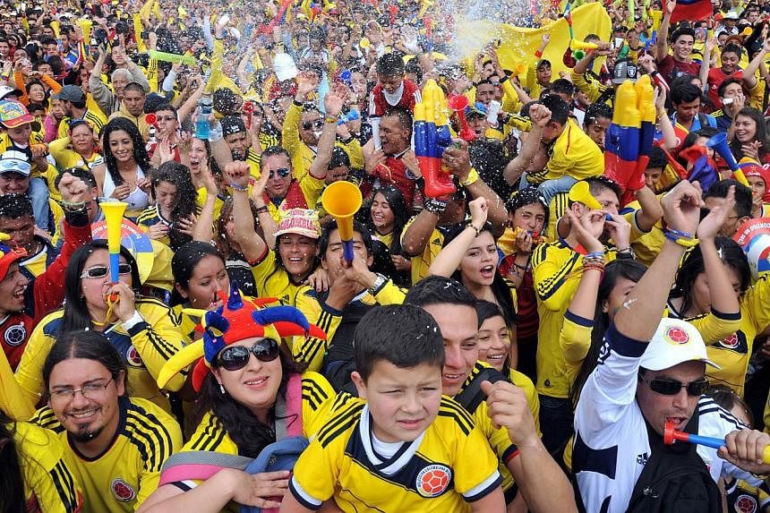 Colombian fans celebrate during the fan fest in Cali, department of Valle del Cauca, Colombia, on June 28, 2014 as they watch the FIFA World Cup Brazil 2014 second round match between Colombia and Uruguay in a big screen. -- PHOTO: AFP&nbsp;