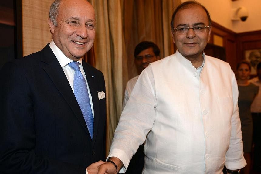 French Foreign Minister Laurent Fabius (L) and Indian Defence and Finance Minister Arun Jaitley shake hands during a meeting in New Delhi on June 30, 2014. Fabius is in India for a two-day official visit during which India and France are expected to 