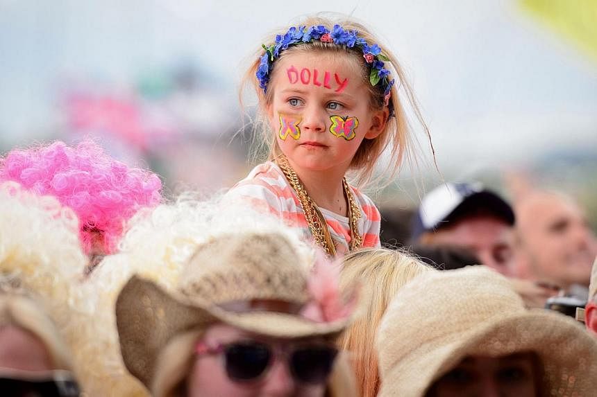 Fans enjoy the music as US singer Dolly Parton performs on the Pyramid Stage, on the final day of the Glastonbury Festival of Music and Performing Arts on Worthy Farm in Somerset, south-west England, on June 29, 2014. &nbsp;-- PHOTO: AFP
