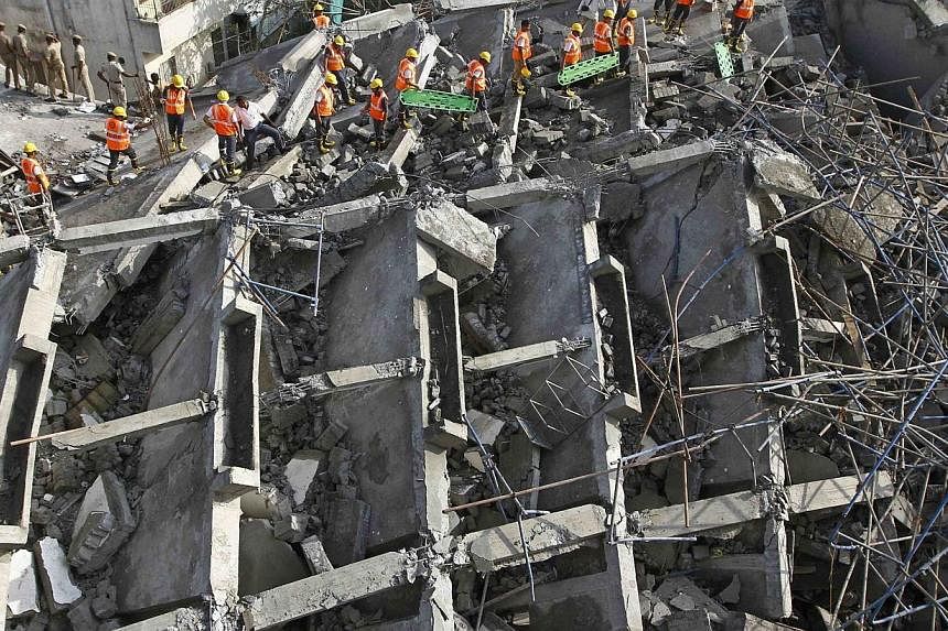 Rescue workers conduct a search operation for survivors at the site of a collapsed 11-storey building that was under construction on the outskirts of the southern Indian city of Chennai June 29, 2014. The confirmed death toll from India's latest buil