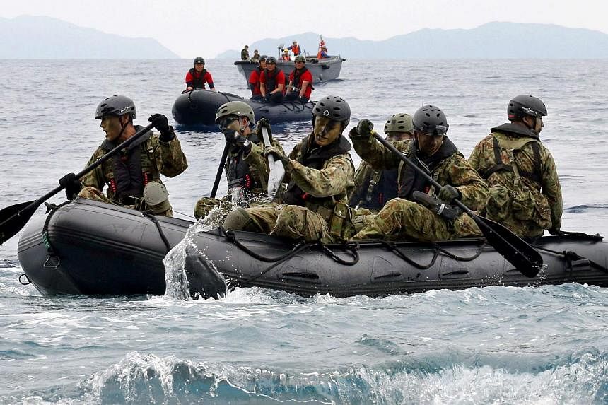 Japan Self-Defense Force (JSDF) soldiers travelling in a rubber boat on the sea approach Eniyabanare Island from JSDF transport vessel Shimokita during a military drill, off Setouchi town on the southern Japanese island of Amami Oshima, Kagoshima pre