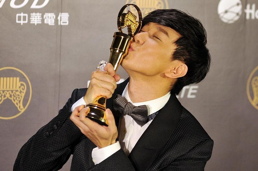 Singaporean singer-songwriter JJ Lin kisses his trophy after winning the Best Mandarin Male Singer at the 25th Golden Melody Awards in Taipei on June 28, 2014. -- PHOTO: AFP