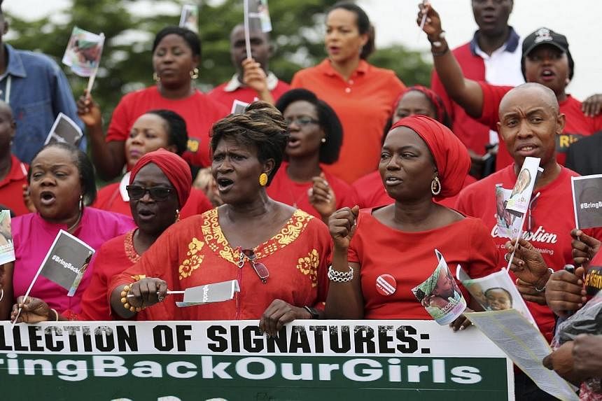 People wearing red holds a banner at a speak-out session of 'bring back our girls' rally in Lagos June 7, 2014.&nbsp;Nigerian troops have arrested a businessman suspected of being at the head of a Boko Haram intelligence network that helped plan the 