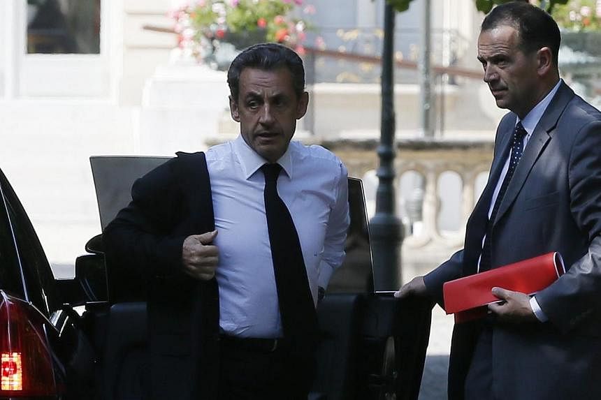 Former French President Nicolas Sarkozy (left) arrives at the National Assembly in Paris June 25, 2014.&nbsp;Mr Sarkozy was on Tuesday, June 1, 2014, detained for questioning in a widening corruption probe, a judicial source told AFP, in an unprecede