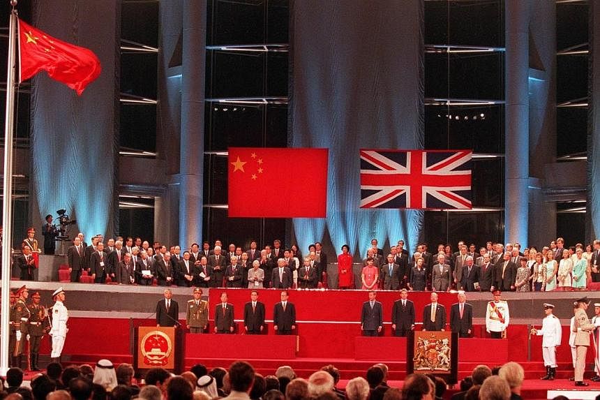 A general view of the handover ceremony showing the Chinese flag (left) flying after the Union flag (right) was lowered in Hong Kong in this July 1, 1997 file photograph.&nbsp;Since Britain handed back colonial Hong Kong in 1997, retired primary scho