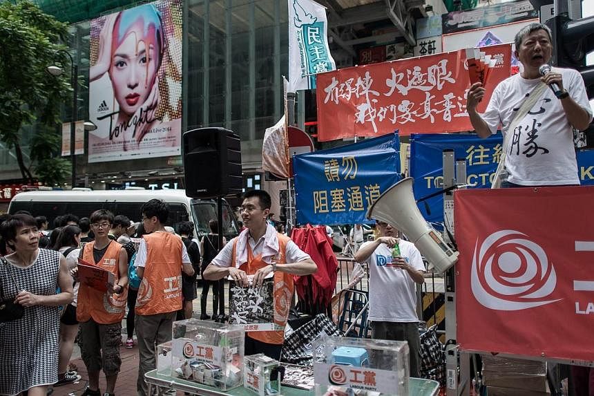 Pro-democracy activists distribute placards and leaflets before a pro-democracy rally seeking greater democracy in Hong Kong on July 1, 2014, as frustration grows over the influence of Beijing on the city. &nbsp;-- PHOTO: AFP