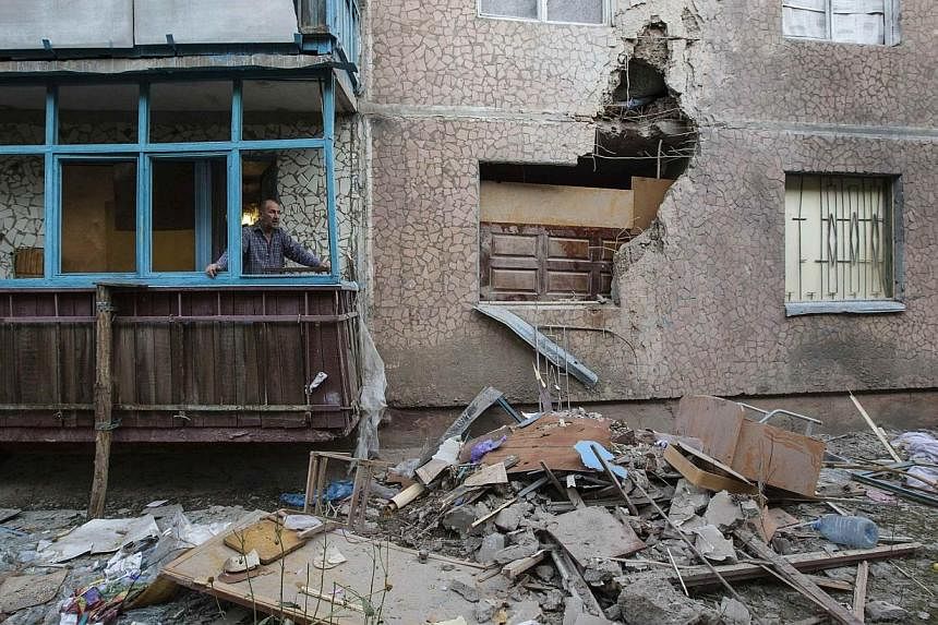 A man looks out of a window of an apartment damaged by shelling in Slaviansk in eastern Ukraine on June 30, 2014.&nbsp;Ukrainian government forces launched air strikes and artillery assaults on pro-Russian separatists in eastern regions on Tuesday, J