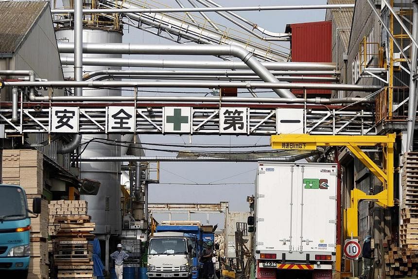 Workers walk at a factory in Tokyo May 29, 2014. Japanese manufacturing activity expanded in June at a faster pace than initially reported, revised data showed on Tuesday. -- PHOTO: REUTERS