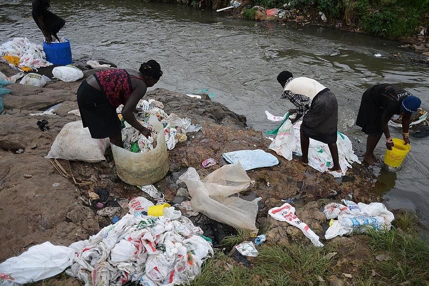 A group of women wash used plastic bags for re-use at the shores of a river on June 24, 2014 in Nairobi.&nbsp;As much as 88 per cent of the open ocean's surface contains plastic debris, raising concern about the effect on marine life and the food cha