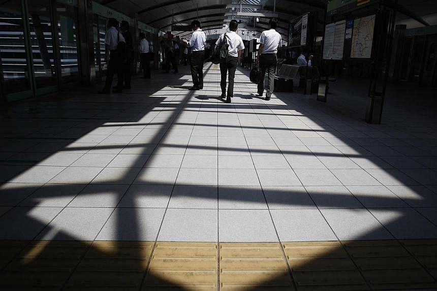 People walk on a platform of a train station at a business district in Tokyo June 19, 2014. -- PHOTO: REUTERS