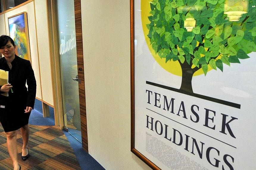 An employee of state-linked Singapore investment firm Temasek Holdings Temasek Holdings walks along the corridor of their offices in Singapore on Aug 25, 2009.&nbsp;Temasek Cares, the non-profit philanthropic arm of Temasek Holdings, has set aside $6