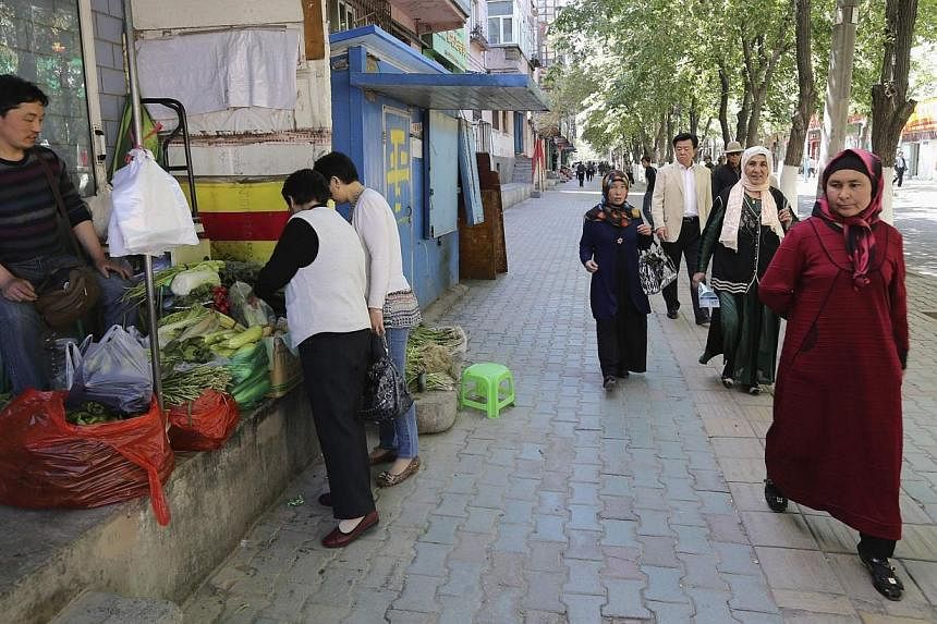 Ethnic Uighur women at an open market in Urumqi, Xinjiang Uighur Autonomous region, on May 25, 2014. -- PHOTO: REUTERS&nbsp;