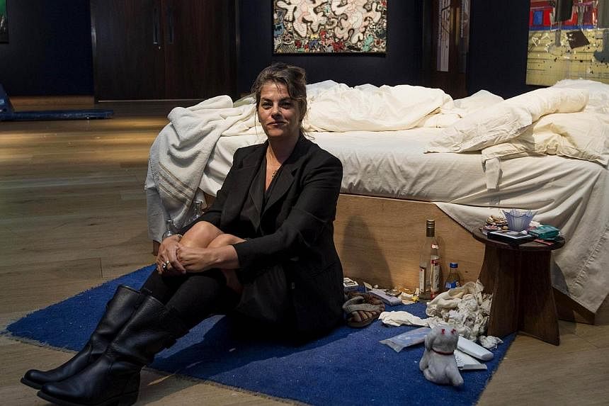 In this file picture taken on June 27, 2014, British artist Tracey Emin sits on her iconic art installation, "My Bed" during a press preview at Christie's auction house. British artist Tracey Emin's controversial 'My Bed' sold for 2.2 million pounds 