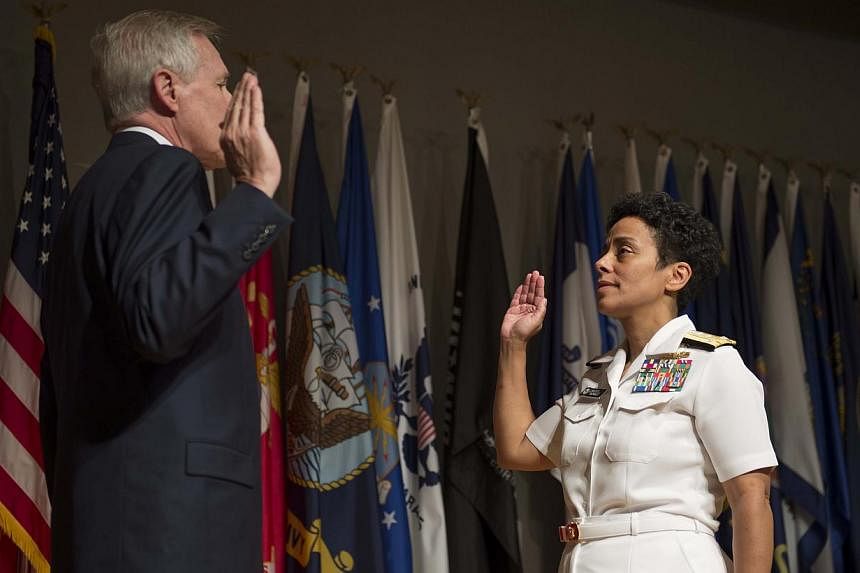 US Secretary of the Navy Ray Mabus (left) gives Vice-Admiral Michelle Howard (right) the oath of office before promoting her to the rank of admiral at the Women in Military Service for America Memorial on July 1, 2014 in Washington, DC. -- PHOTO: AFP