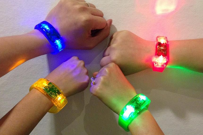 One of the items in this year's NDP Funpack is a sound sensitive LED bracelet, which lights up to the tempo of music. -- ST PHOTO: YEO SAM JO