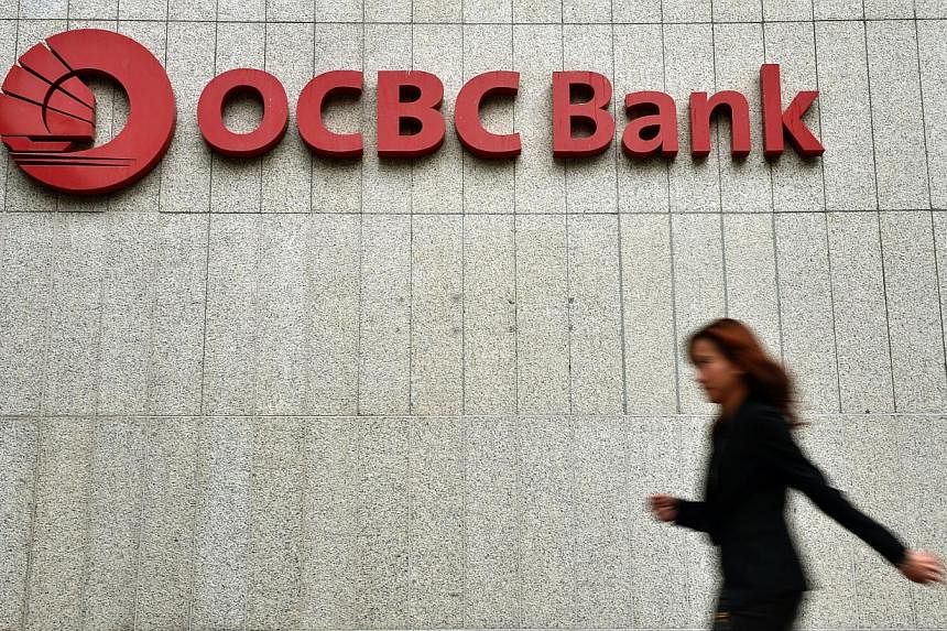 A woman walking past the OCBC Tower at Chulia Street on April 1, 2014.&nbsp;OCBC Bank formally launched its second-largest branch at Orchard Road on Thursday. -- ST PHOTO:&nbsp;KUA CHEE SION