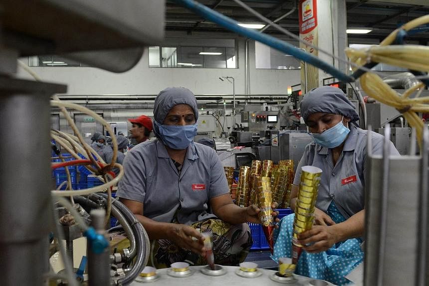 Indian factory workers place ice cream cones on the production line at the Havmor Ice Cream Limited plant at Naroda near Ahmedabad on May 9, 2014.&nbsp;Inflation is still uncomfortably high in India and the new government should avoid fiscal slippage