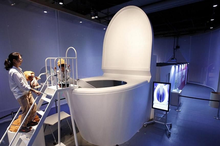 A girl prepares to slide down into a five-metre toilet at an exhibition titled Toilet!? Human Waste and Earth's Future at the Miraikan National Museum of Emerging Science and Innovation in Tokyo July 3, 2014. Visitors are to slide into a toilet bowl 