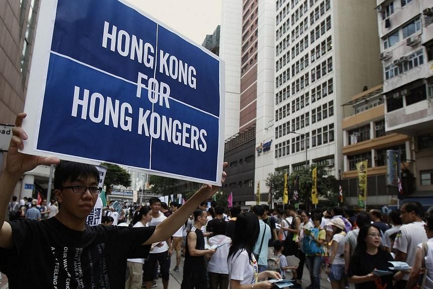 A protester carries a placard during a mass protest demanding universal suffrage in Hong Kong on July 1, 2014.&nbsp;China must give Hong Kong the space to debate its political future and allow the “vigorous” voices of the city’s residents to be