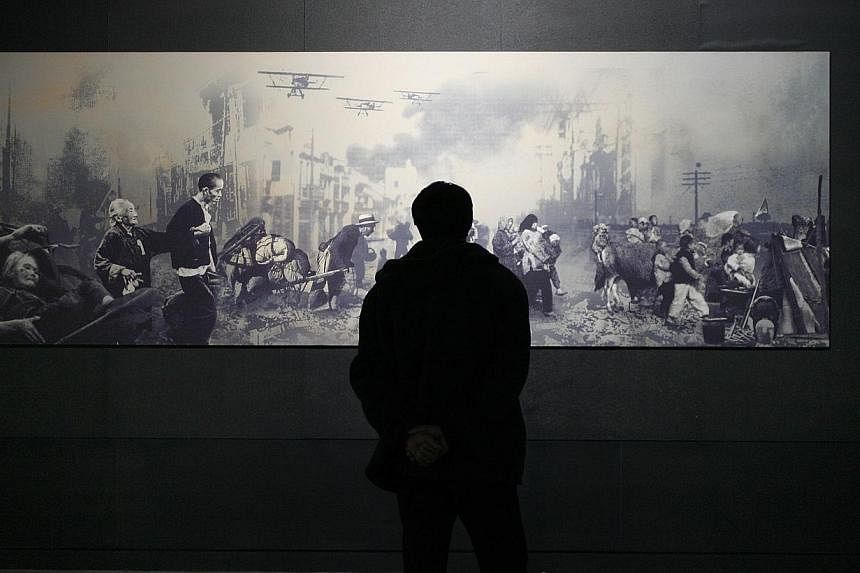 This file photo taken on December 27, 2006 shows a man looking at a painting on display depicting civilians fleeing Shanghai during the Japanese imperial army's war of aggression and conquest on mainland China which lasted from 1931 to 1945, at the M