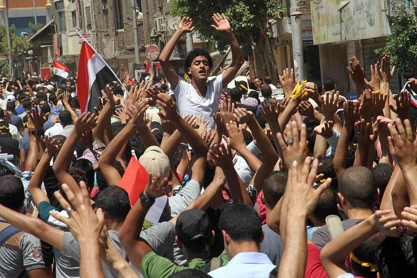 Egyptian supporters of the Muslim Brotherhood movement shout slogans during a rally to mark the first anniversary of the military ouster of president Mohamed Morsi on July 3, 2014 in Cairo's Mattarya district. Egyptian police on Thursday swiftly quas